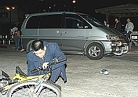 　昨日深夜介壽村遊樂場彎道前發生腳踏車與客車的車禍，圖中警方正在進行各項車禍數據測量，警察身後是車禍客車以及學生的右腳球鞋。（圖／文：張登傑）