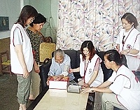 衛生局長期照護中心及社區健康營造中心志工們進行健康服務,並登門幫行動不便的阿公阿婆量血壓。(圖/文:曹重偉)