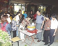 　馬港社區發展協會美食研習教導地瓜餃製作，婦女們輪番上陣，練習用木杵用力攪拌，場面熱鬧有趣。（圖／文：曹重偉）