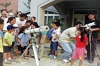 仁愛國小學童們透過天文望遠鏡,爭相目睹難得的「金星凌日」天文奇觀。(圖/文:曹重偉)