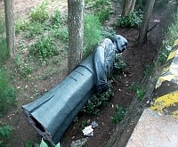 中山門蔣公銅像發生傾斜先行遷移後,就近暫置於路邊草叢裡以便日後修復,但卻引來部份鄉親的不滿。(圖/文:曹重偉)