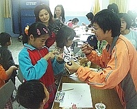 　仁愛國小舉辦國劇臉譜親子彩繪活動，家長與小朋友一起動手上色，氣氛溫馨。（圖／文：曹重偉）