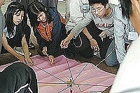 十人一枝筆怎麼寫?東引國中小舉辦「青少年成長營」,圖中學員以同心協力相互協調的合作方式進行塗鴉。(圖/文:張登傑)