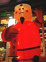 　地區某家業者為迎接春節商機，在店面大門口放置了約一層樓高的財神娃娃。（圖／文：張登傑）
