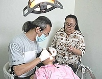 　林雅青（左）、吳宏真兩位醫師為地區小朋友做口腔健康檢查及裂隙封填。（圖／文：曹重偉）