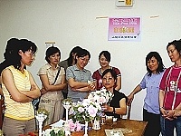 　山隴社區發展協會本週舉辦花藝研習活動，曹曉芬老師指導學員製作半圓形人造桌上花。（圖／文：張登傑）