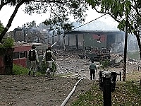  　重回事發現場，彈材庫房只剩鋼筋，鄰近房舍面目全非，消防人員也不斷支援入內及噴水柱降溫。（圖／文：曹重偉）