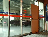 　南竿航空站航站大廈大門玻璃上禮拜又被旅客以推車撞破，航站大廈白天缺一片門，晚上則以門板遮擋。（圖／文：張登傑）