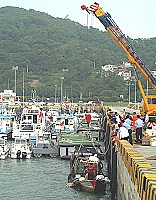 　被查扣停靠在福澳港的大陸漁船閩連○五一一四八號昨日發生翻覆沉船意外，大型吊車開抵現場協助救災。（圖／文：張登傑）