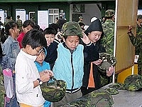 　參加營區開放參觀活動的小朋友，好奇的戴上鋼盔，感受官兵保家衛國的高尚情懷。(圖／文：朱宏基)