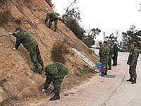 　軍方派員前往仁愛村道路旁的電池斷層開挖進行清理，各類古老電池重見天日。（圖／文：曹重偉）
