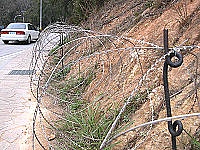 　防區在仁愛村「電池山」周邊佈置的鐵絲網帶有流刺且佔用人行道，相當危險，經地方反映，已將鐵絲網撤走。（圖／文：曹重偉）