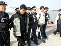 　衛豐保全運鈔車搶案嫌犯李漢揚（左二）、李金瓚兄弟由中國「新海峽號」遣返至南竿福澳港，後於下午一時三十分搭乘空警直昇機押返台北。（圖／文：曹重偉）