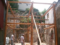 　工人們站在兩層樓高的木結構上趕進度，興建「鐵板生活館」。（圖／文：邱竟瑋）