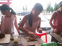　福澳社區發展協會昨舉辦「暑期畫陶樂」活動，一名小朋友專注地捏塑自己的泥雕作品。（圖／文：邱竟瑋）