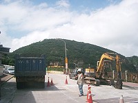　縣府在南竿清水施作寬頻管道工程，一名工地人員引導砂石車通過。（圖／文：邱竟瑋）