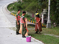 　軍中割草機除草時會特別由弟兄以甘蔗板擋住削起的飛沙走石，廣獲民眾好評；鄉長朱秀平表示待人手充裕後立即跟進。（圖／文：曹重偉）