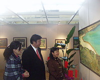 　縣長陳雪生在郭淑媛導覽下，欣賞一幅名為「寧靜海」的油畫。（圖／文：邱竟瑋）