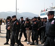 　二十五名台灣重大刑事（通緝）犯昨日由大陸「海峽號」載抵馬祖，隨即由刑事局押解返台歸案，其中最受人矚目的便是前中興銀總經理王宣仁（第一列中間）。（圖／文：劉秋月）
