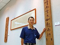 曹常春巧用回收原木皮凳面以行書精心雕刻,平時作品掛在平鎮老家的大廳。(圖:曹常強提供)