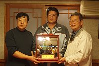 　中正國中小人事管理員陳華安榮退，縣府參議曹爾莆代表致贈禮品。（圖：人事室提供）