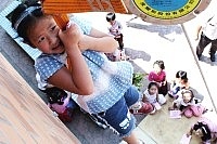 介壽國小學童昨日舉行消防安全體驗活動,圖中的小女孩正在操作緩降機下降,害怕得不敢將頭往下看。(圖/文:張登傑)